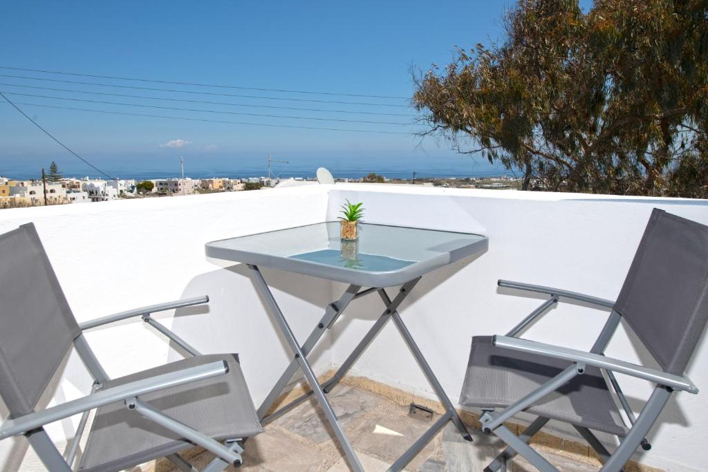 a table and two chairs sitting on a balcony at Thira Santo Apartments in Karterados