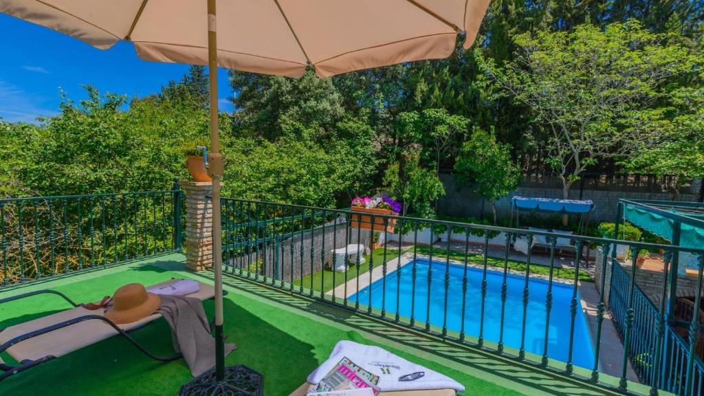 balkon z parasolem i basenem w obiekcie Cortijo la Algallumbilla Carcabuey by Ruralidays w mieście Carcabuey