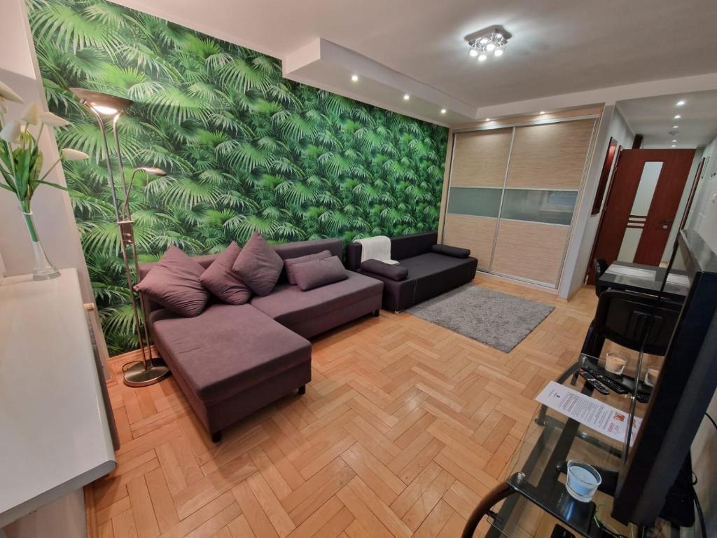 sala de estar con sofá y pared verde en PrzyMorze, Park i czas nad Zatoką - doskonałe miejsce na wygodny i udany urlop w Trójmieście, en Gdansk