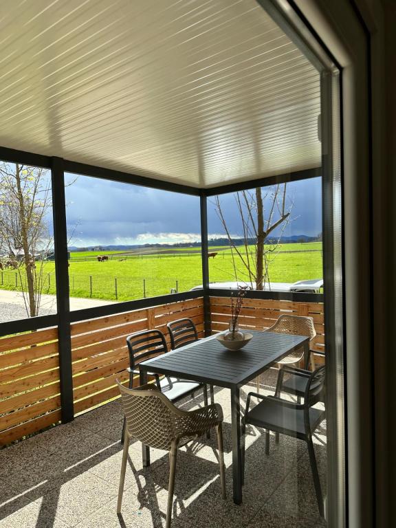 a patio with a table and chairs and a view of a field at BB HOUSE KOLPA RIVERSIDE in Metlika