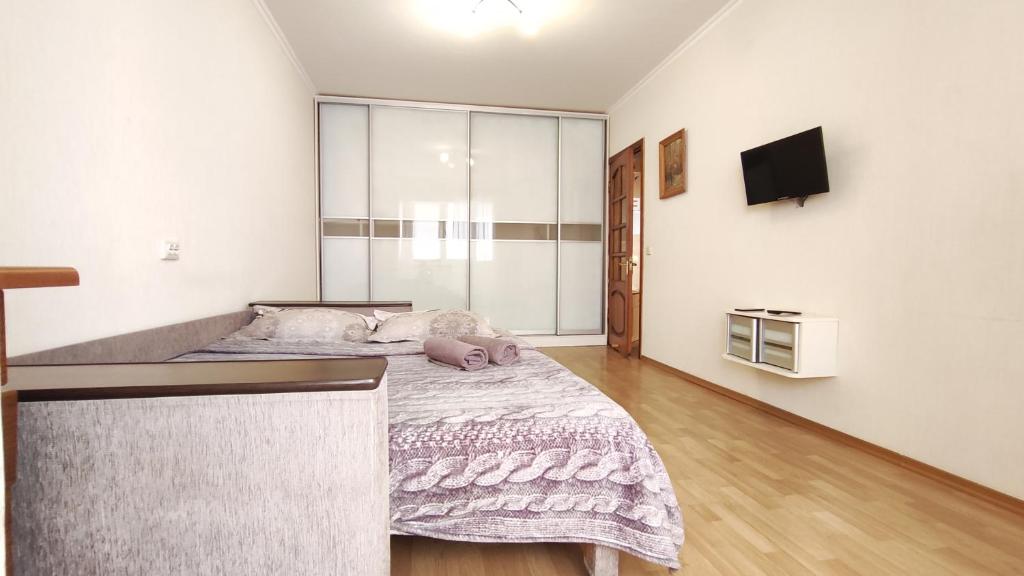 ein Schlafzimmer mit einem Bett und einem TV an der Wand in der Unterkunft Олександрійський бульвар 125 CityRooms in Bila Zerkwa