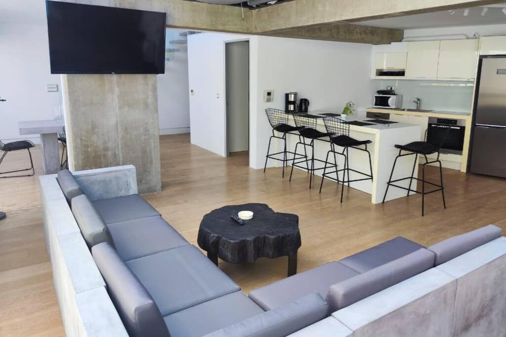 a living room with a couch and a table and a kitchen at Gazi pool house in Athens