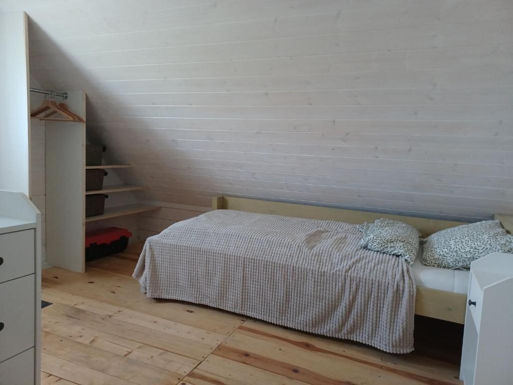 a small bedroom with a bed and a staircase at Domki skowronki in Filipów