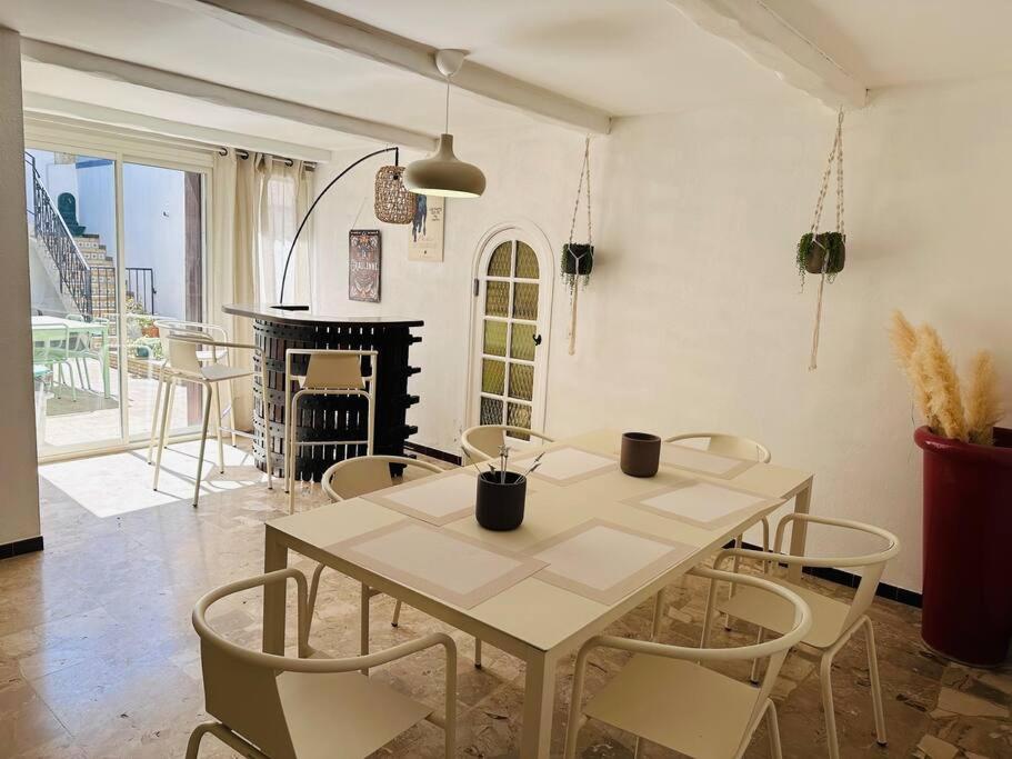 a dining room with a table and chairs and a fireplace at La forge du papé in Aigues-Mortes