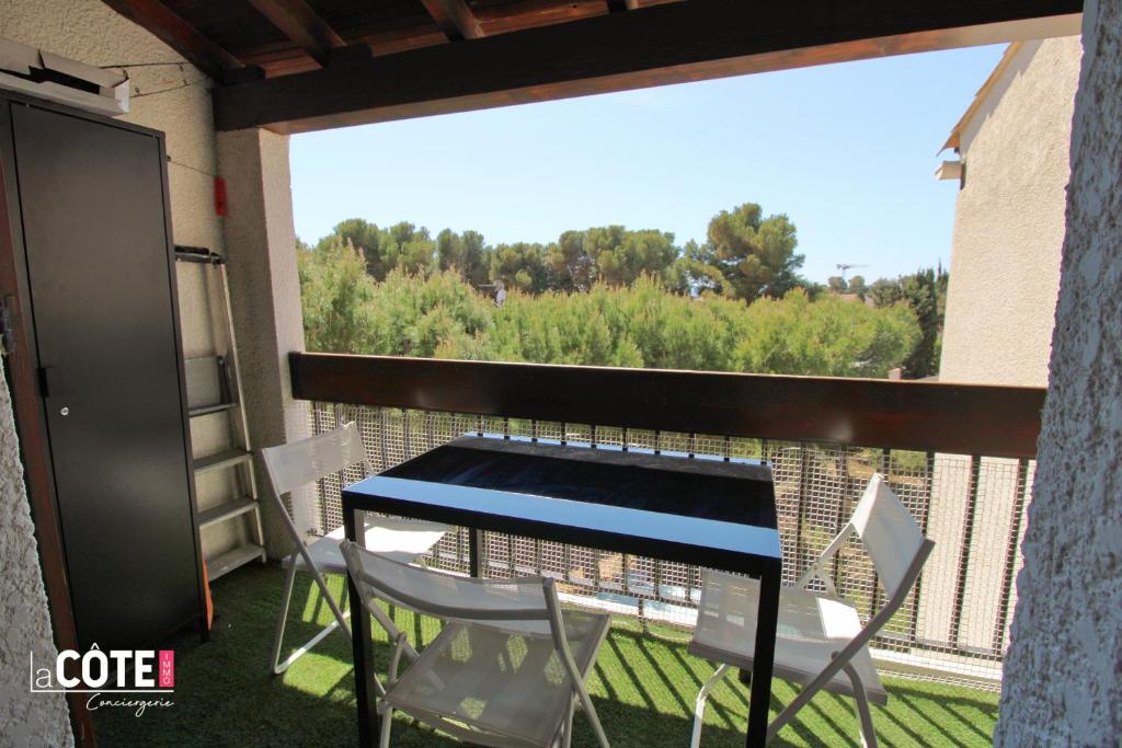 einen Balkon mit einem Tisch und Stühlen in der Unterkunft LES EMBRUNS T2 côte bleue lacote immo 3 in Sausset-les-Pins