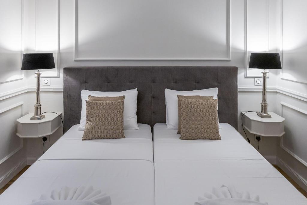 a bedroom with a large white bed with two lamps at Belle Boutique in Sliema