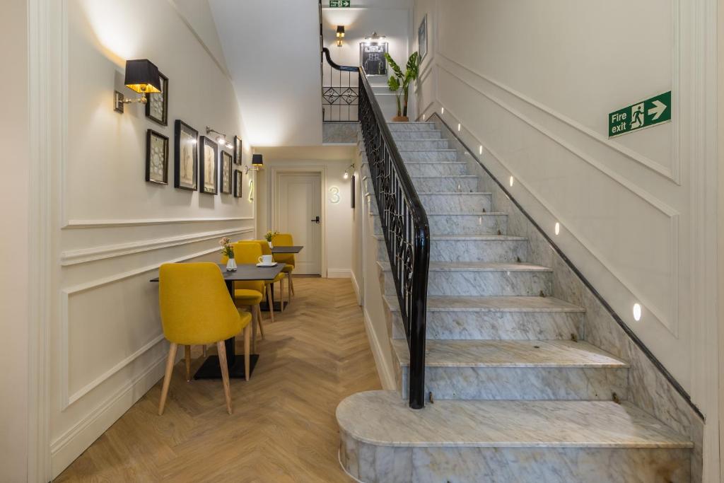 a staircase with yellow chairs and a table in a room at Belle Boutique in Sliema