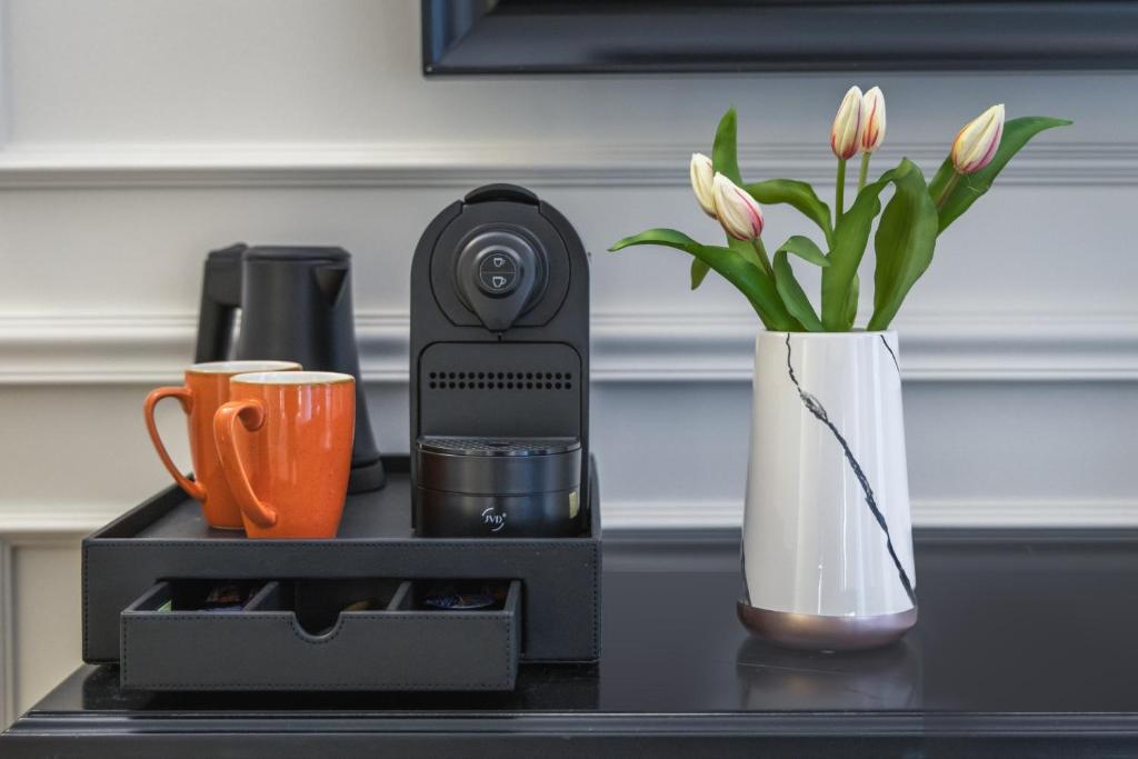 a table with a coffee maker and a vase with flowers at Belle Boutique in Sliema