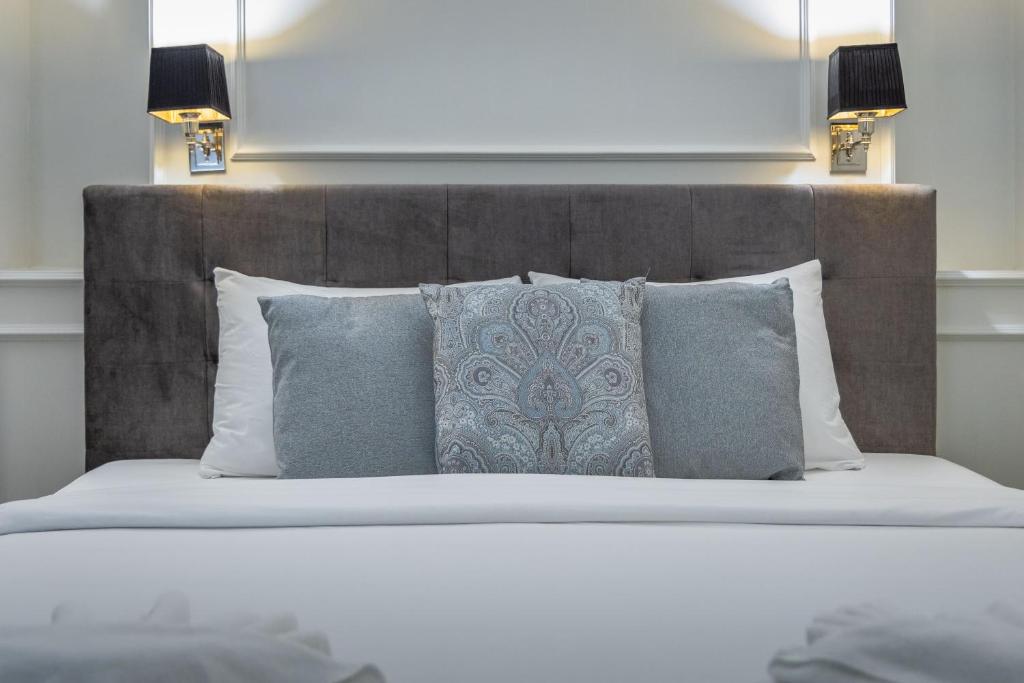 a bedroom with a large bed with pillows and a headboard at Belle Boutique in Sliema