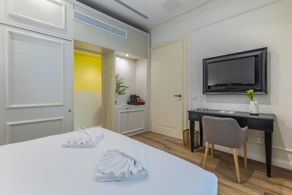 a bedroom with a bed and a desk and a tv at Belle Boutique in Sliema