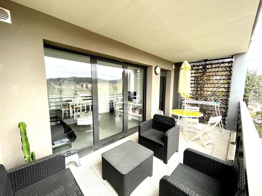 d'un balcon avec des chaises noires et une table, ainsi que d'une terrasse. dans l'établissement Spacieux T2 + Parking à 5 min d'Aix, à Aix-en-Provence