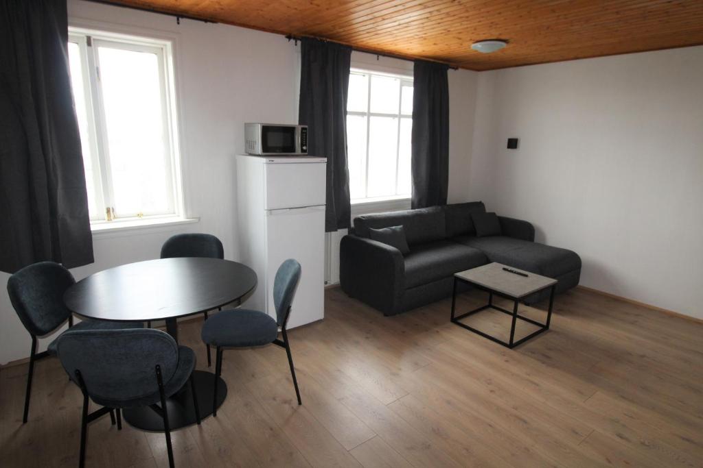 uma sala de estar com uma mesa e um sofá em Húsavík Apartments em Húsavík