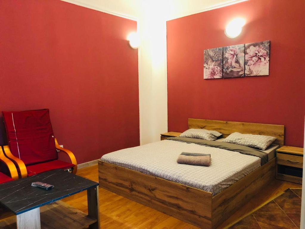 a bedroom with a bed and a red wall at Nights bucharest apartment oldtown in Bucharest