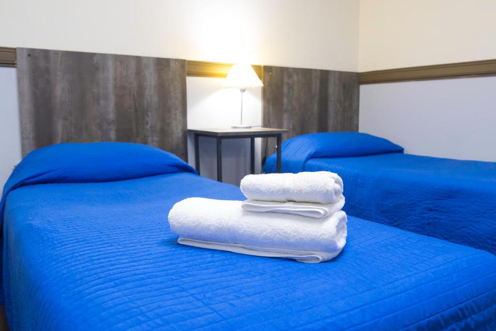 two beds with towels sitting on top of them at Apartamentos Matices in El Calafate