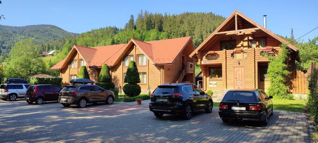 a group of cars parked in a parking lot in front of houses at Mini Hotel Zakrut in Tatariv