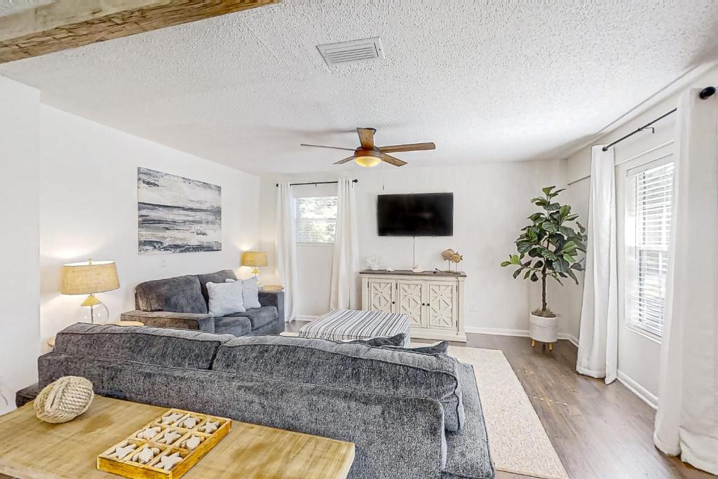 a living room with a couch and a ceiling fan at Dog-friendly home with fenced yard, patio, grill, & park across the street in Saint Augustine