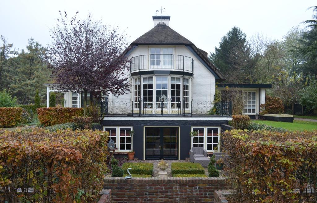 a large white house with a balcony on top of it at Veld en Bosch in Leusden