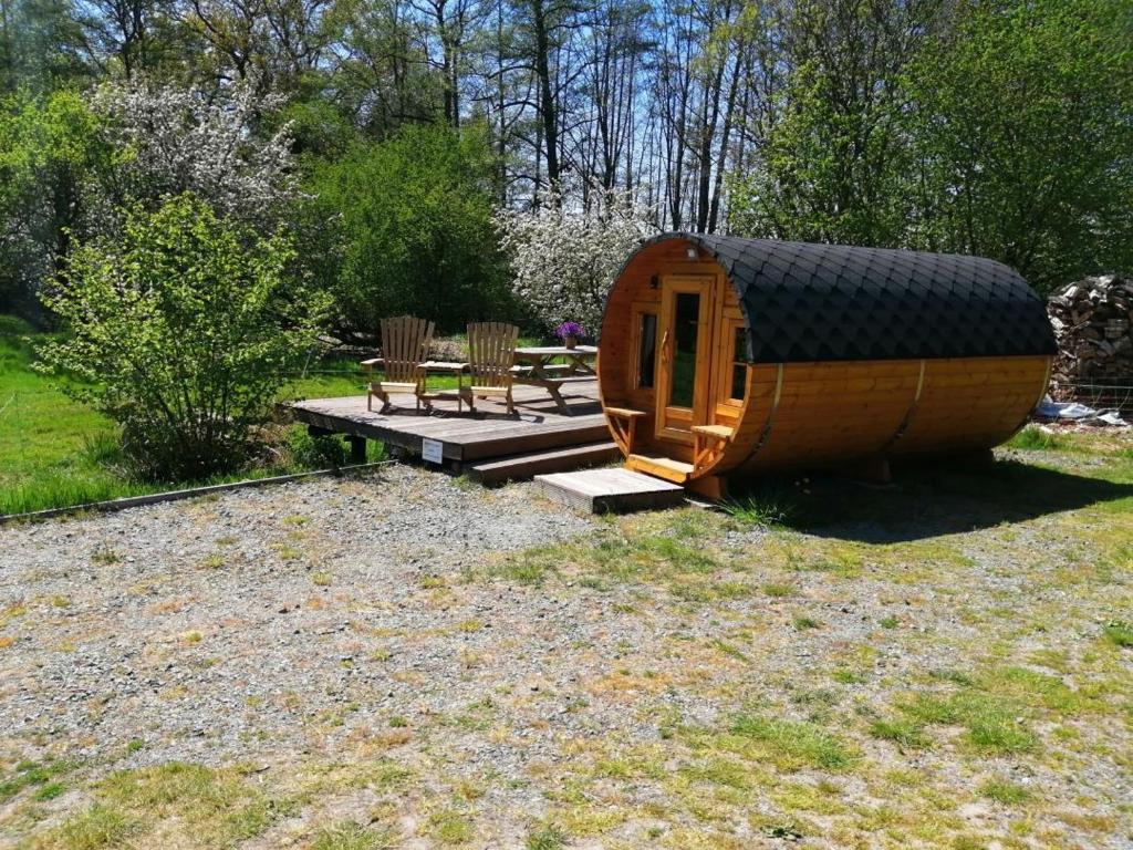 a small wooden cabin with a table and chairs at NEU! Campingfass Milchschafhof in Bremervörde