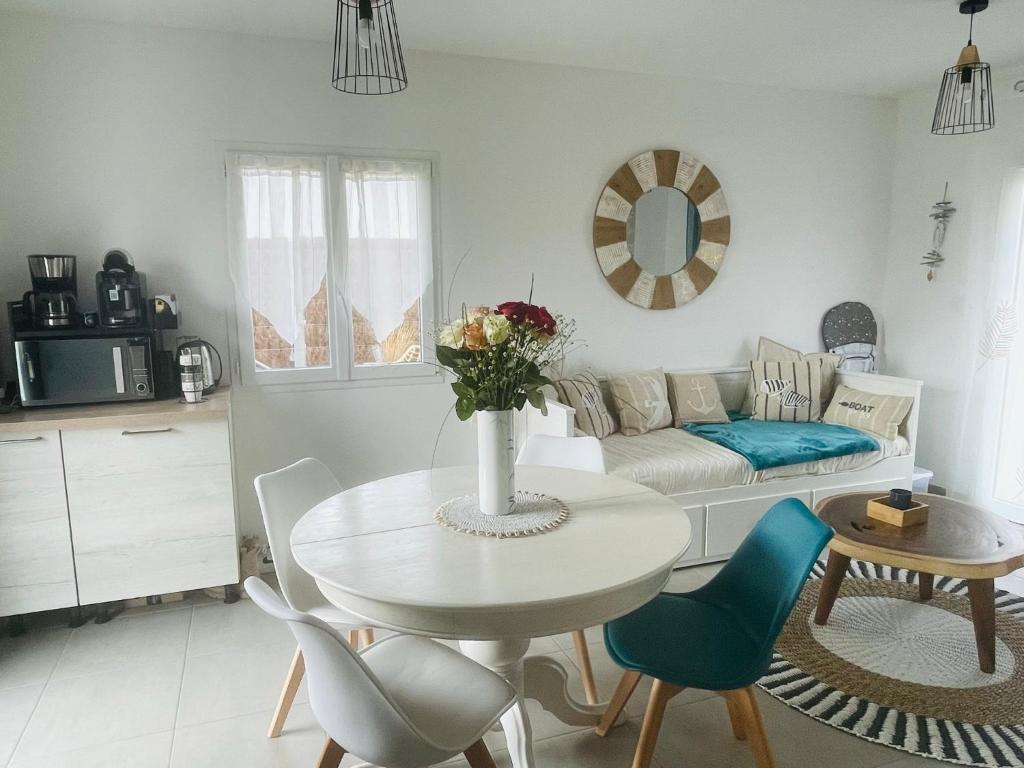 een woonkamer met een tafel en een bank bij Cottage Dune in Saint-Jean-de-Monts
