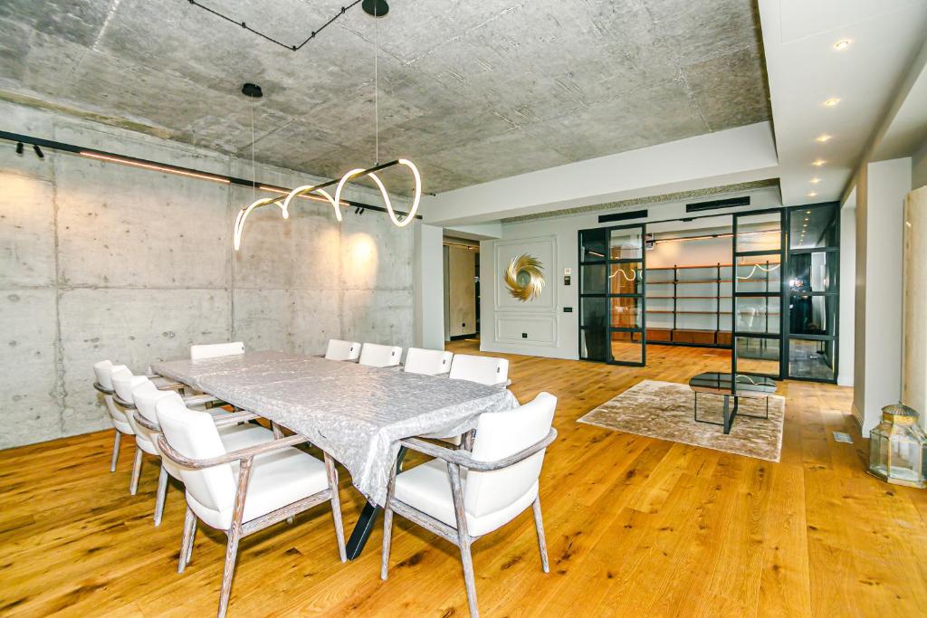 a dining room with a table and white chairs at Park Vurğun Residance Loft Designer in Baku