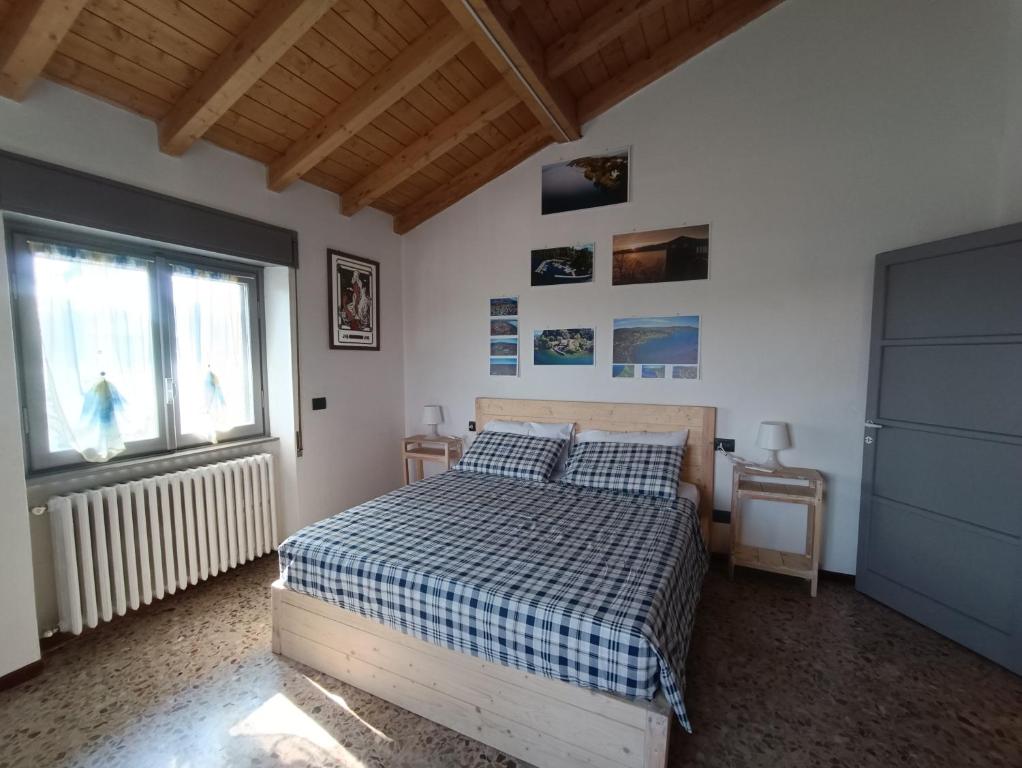 ein Schlafzimmer mit einem Bett mit einer karierten Decke und einem Fenster in der Unterkunft Casa Le Fornaci in Ispra