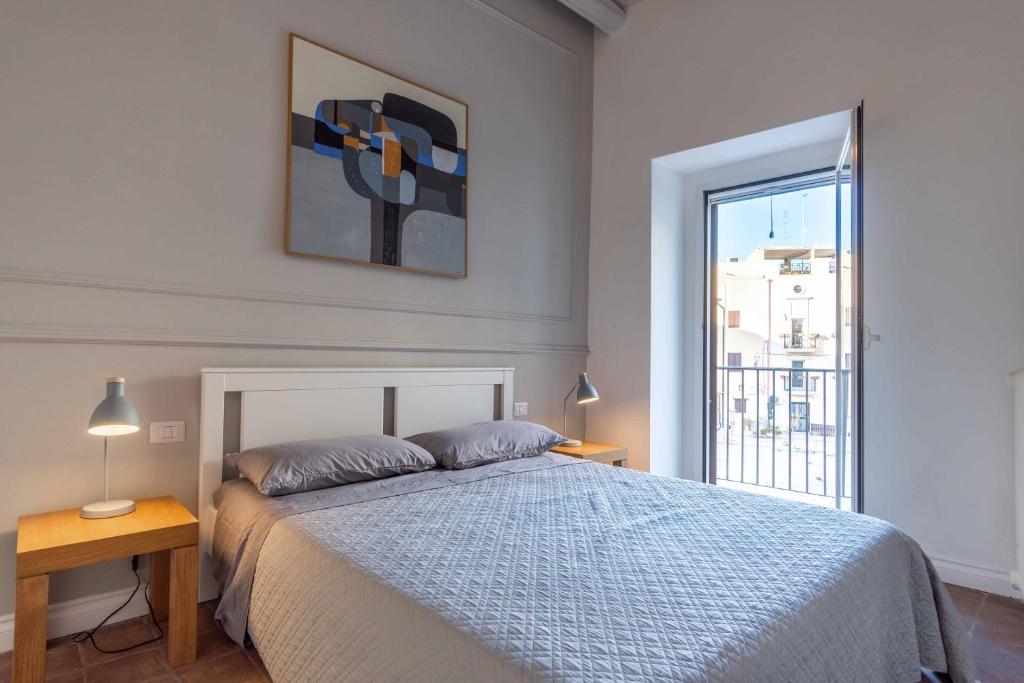 a bedroom with a bed and a large window at San Pietro Apartment in Bari