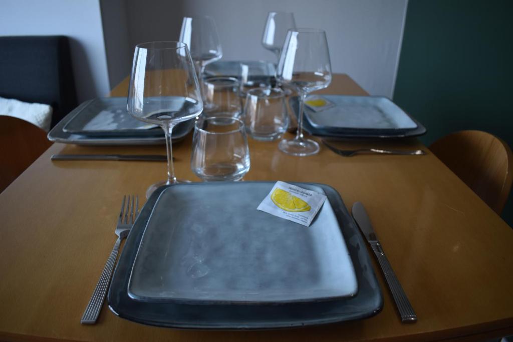a table with a plate and wine glasses on it at Studio, vue exceptionnelle sur le port de pêche in Les Sables-d&#39;Olonne