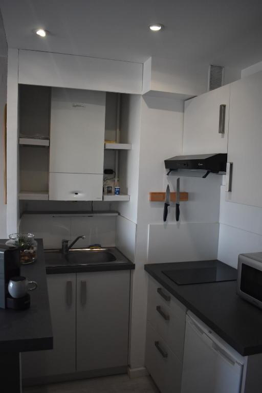 a kitchen with white cabinets and a sink at Studio, vue exceptionnelle sur le port de pêche in Les Sables-d&#39;Olonne