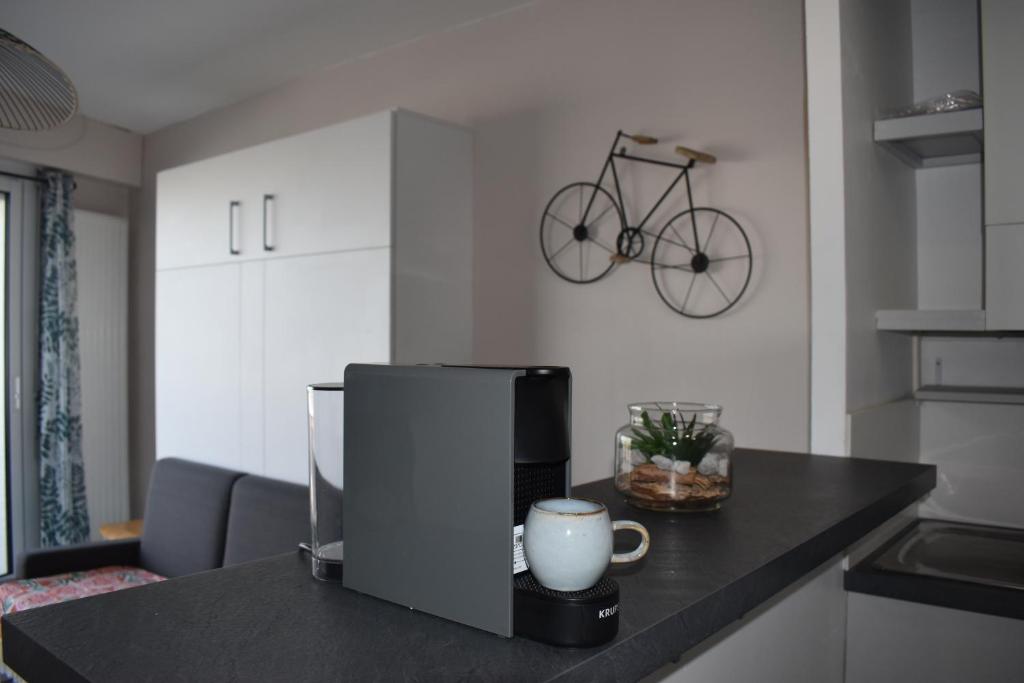 a kitchen counter with a coffee maker and a bike on the wall at Studio, vue exceptionnelle sur le port de pêche in Les Sables-d&#39;Olonne