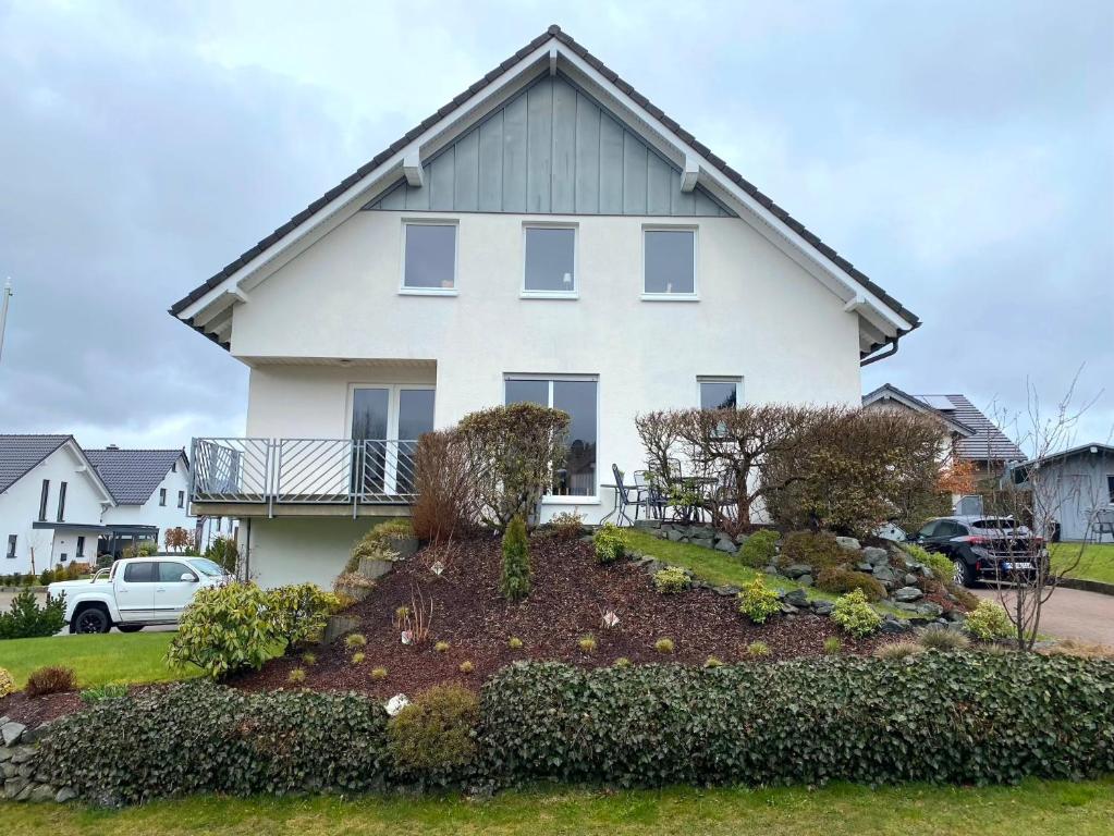 een groot wit huis met een tuin bij Ferienwohnung Bergsee in Winterberg
