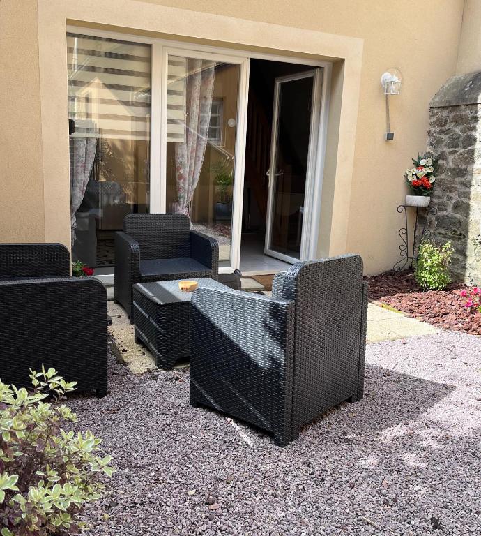 un groupe de chaises et une table devant une maison dans l'établissement Duplex terrasse, à Fréhel