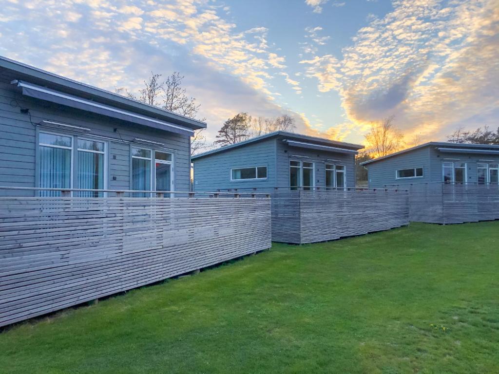 een rij van drie huizen in een tuin bij Kostergården in Sydkoster