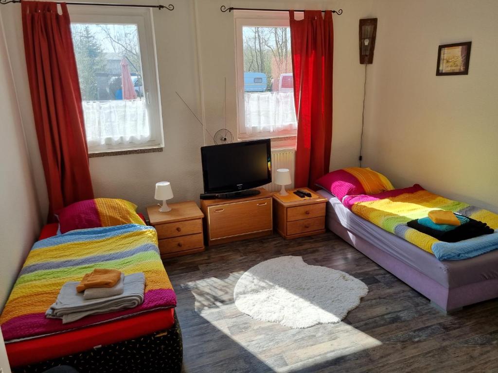 a room with two beds and a tv in it at FEWO NEUBEEREN in Großbeeren