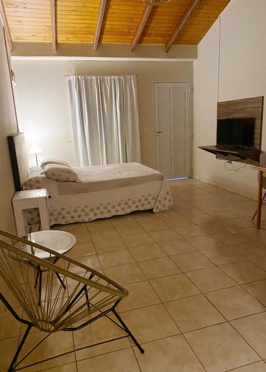 - une chambre avec un lit, une télévision et une chaise dans l'établissement Departamento Céntrico en Eldorado, à Eldorado