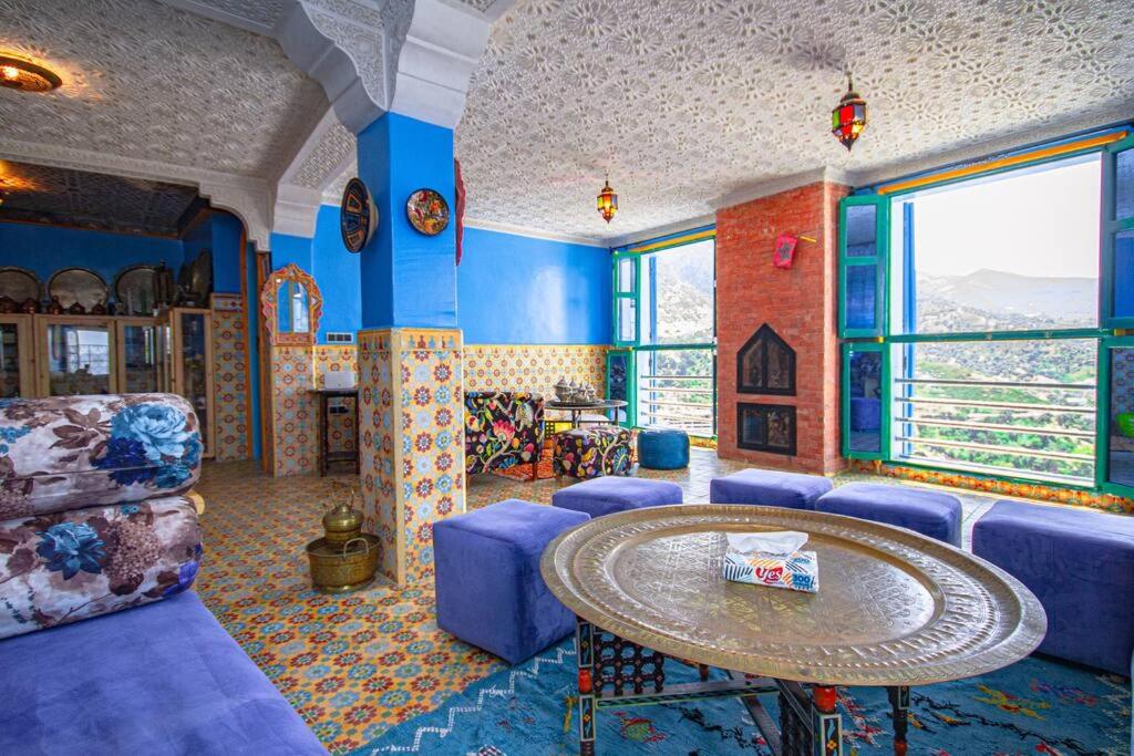 sala de estar con muebles azules y mesa en Amazing view and unique design in historic medina en Xauen