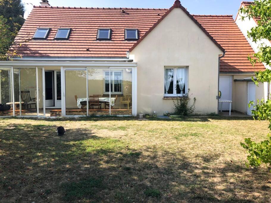 ein weißes Haus mit Terrasse und Garten in der Unterkunft Grande maison proche de Paris in Champcueil