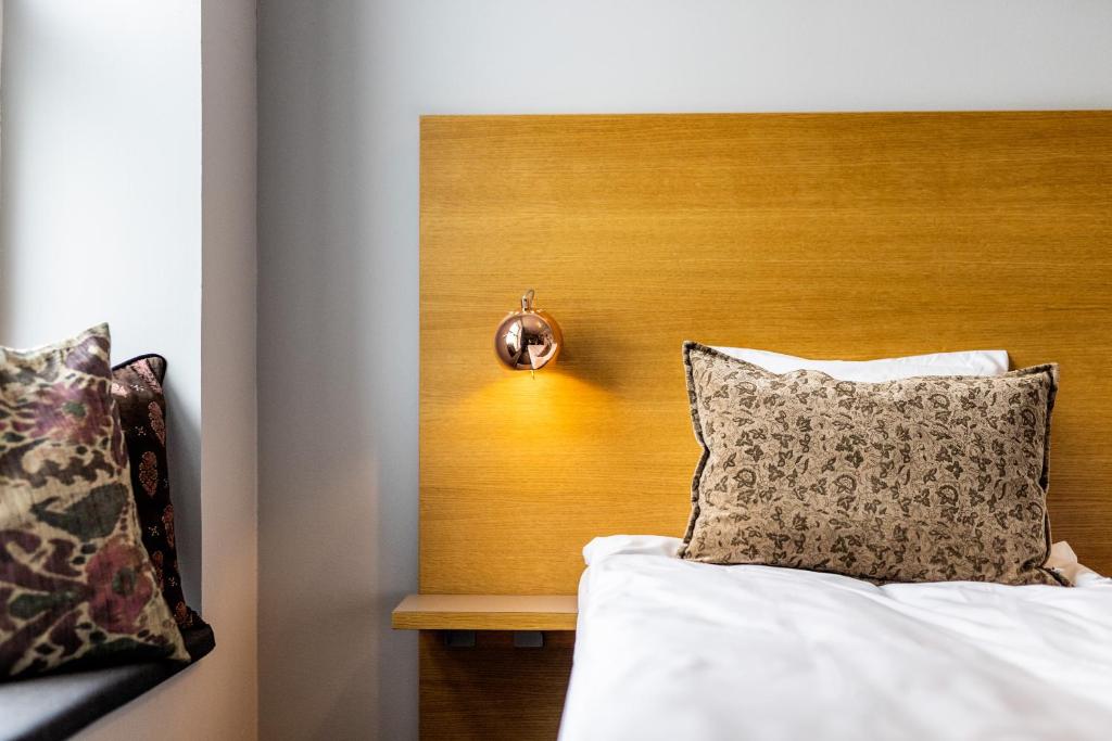 a bed with a wooden headboard and a pillow at Aalborg Airport Hotel in Aalborg