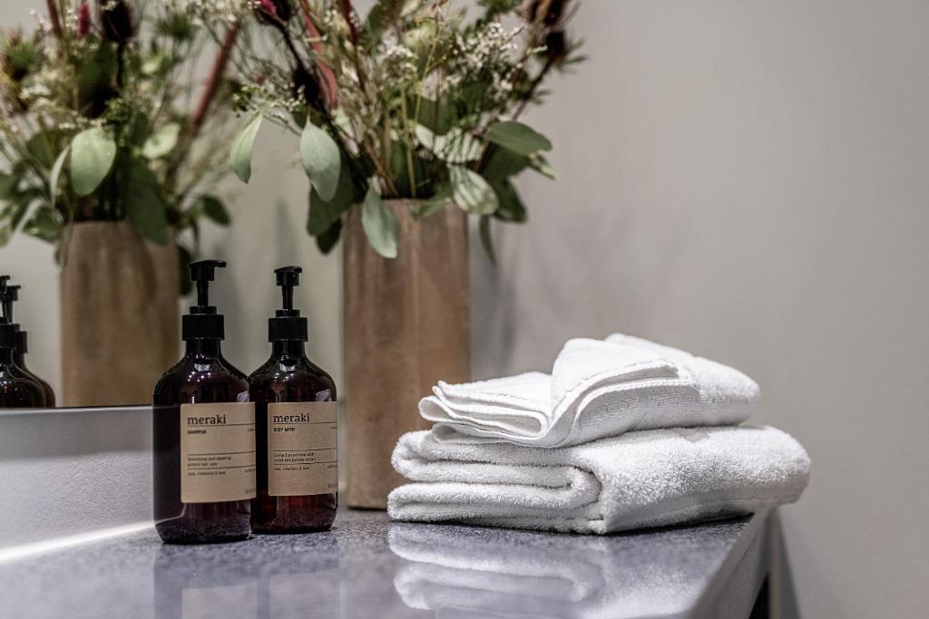 two bottles of wine sitting on a counter with towels at Aalborg Airport Hotel in Aalborg