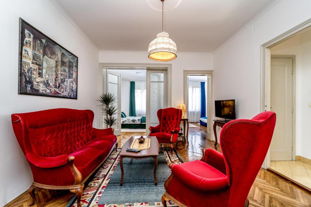 ein Wohnzimmer mit roten Stühlen und einem Tisch in der Unterkunft Apartment Kneza Milosa in Belgrad