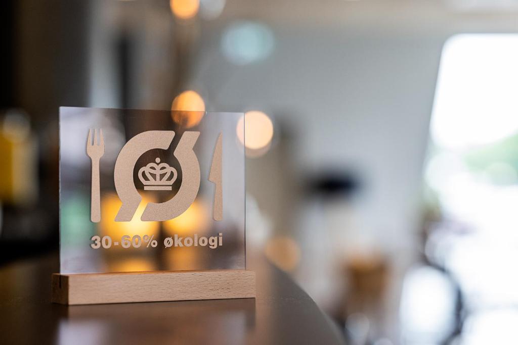 a sign on a table with a plate and a fork at Aalborg Airport Hotel in Aalborg