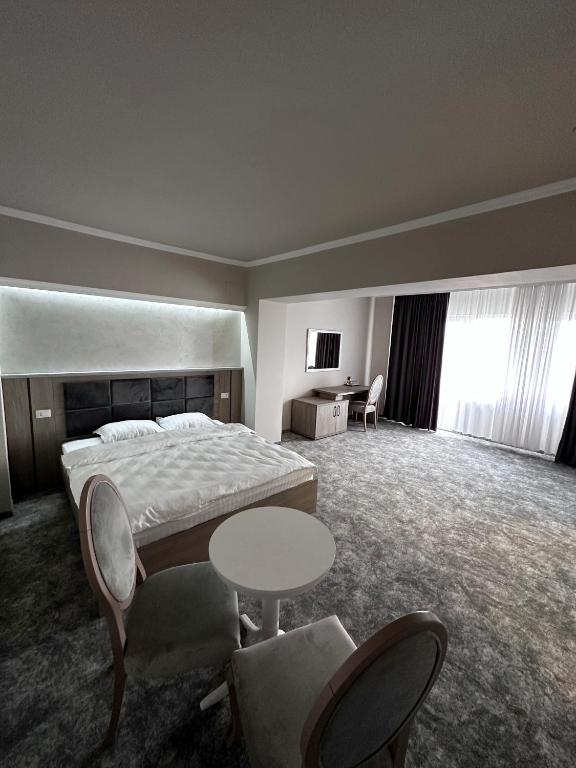 a hotel room with a bed and a table and chairs at Romula Imperial in Caracal