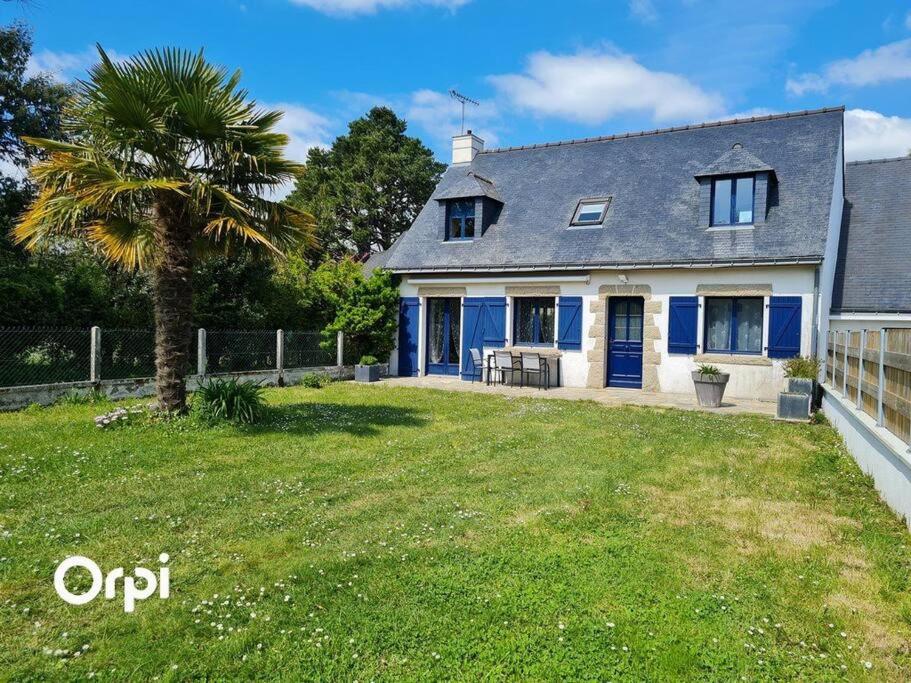 une maison avec un palmier dans la cour dans l'établissement Ref 022 - Grande maison pour dix personnes avec jardin et palmier, à Arzon