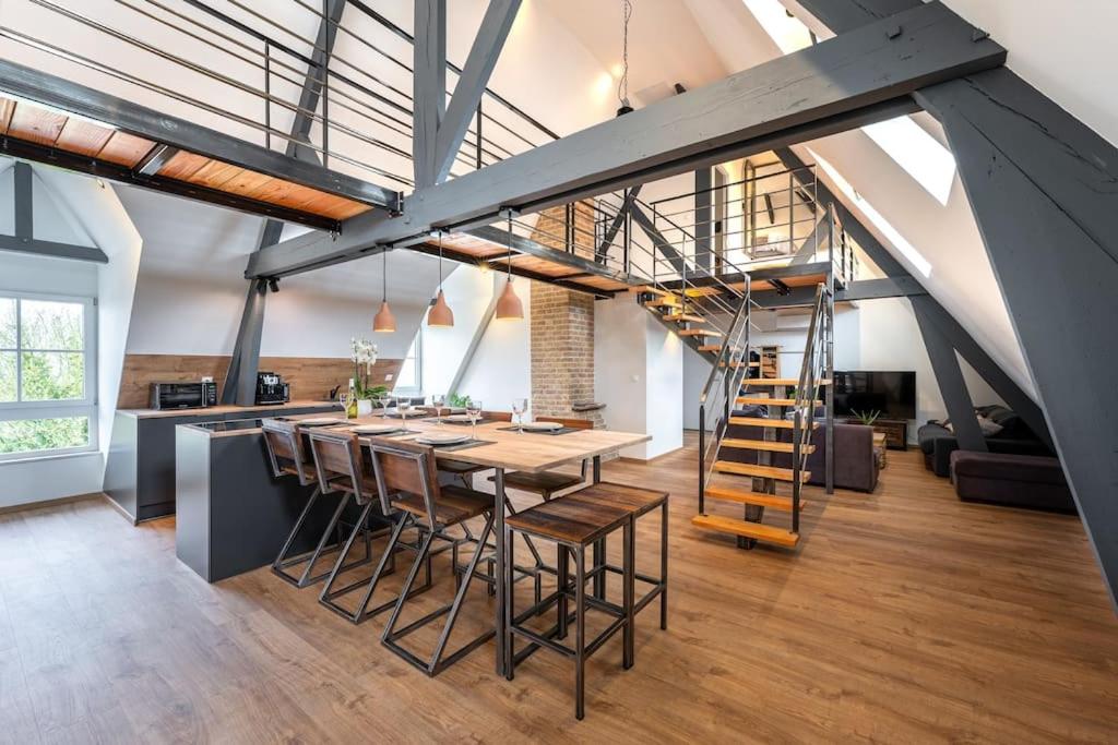 a kitchen and dining room with a table and chairs at Loft 'Le Télégraphe' in Cassel
