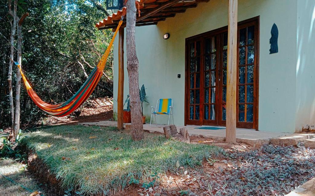 a house with a hammock in front of a house at casaOCA in Lençóis