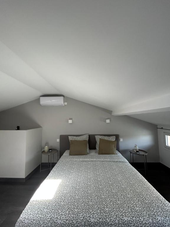 een slaapkamer met een groot bed op zolder bij Duplex lumineux rénové avec terrasse et bains de soleil in Cannes