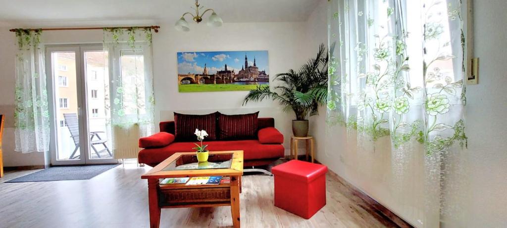a living room with a red couch and a table at Dresden Großer Garten in Dresden