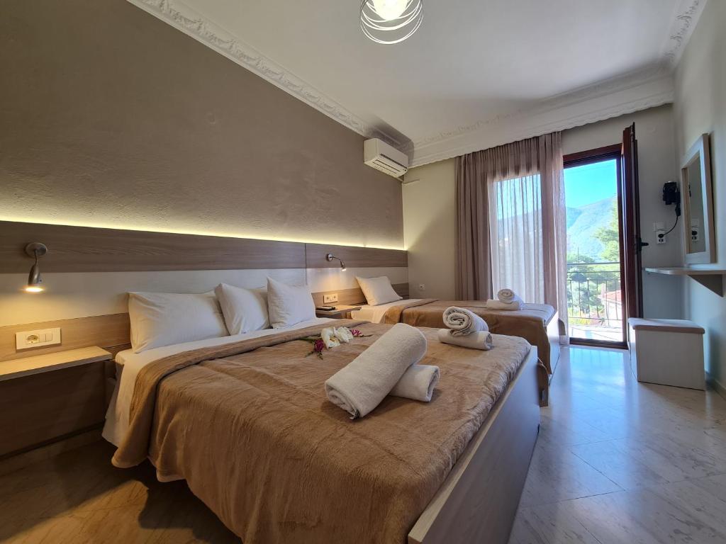 Zigos Apartments في إيغومينيتسا: غرفه فندقيه سريرين عليها مناشف