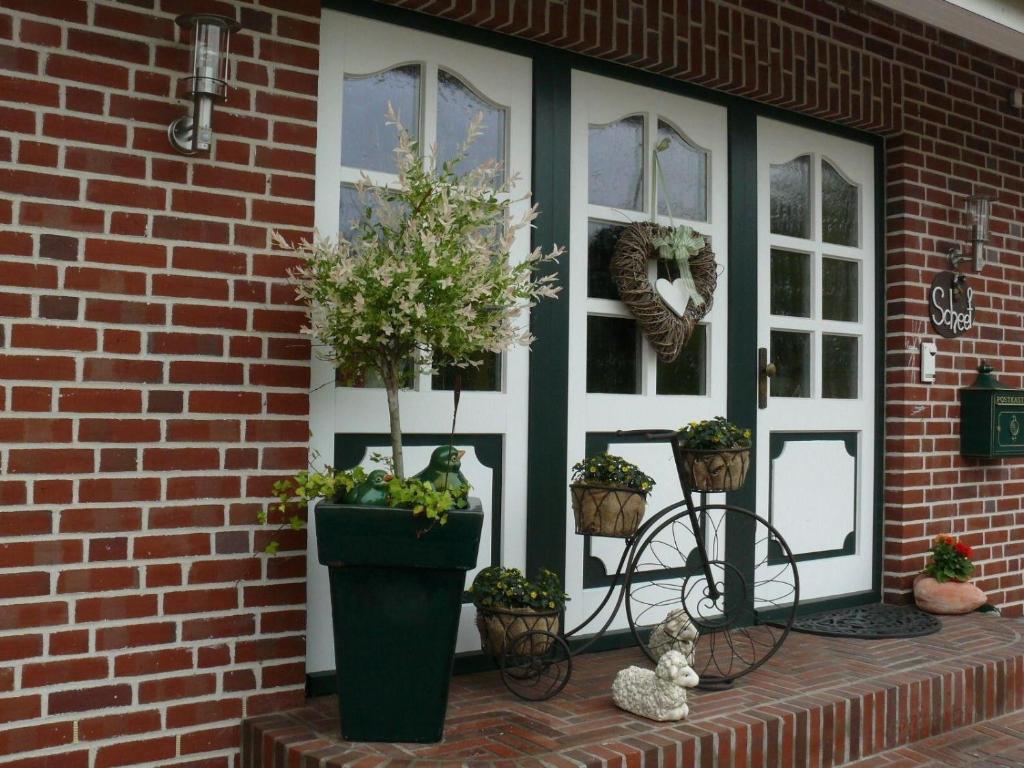 eine Veranda mit Topfpflanzen und einer Ziegelwand in der Unterkunft Ferienhaus Ankerplatz in Fehmarn