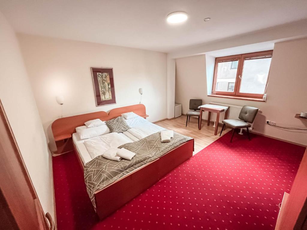 sypialnia z łóżkiem i czerwonym dywanem w obiekcie Penzión Tavel w Preszowie