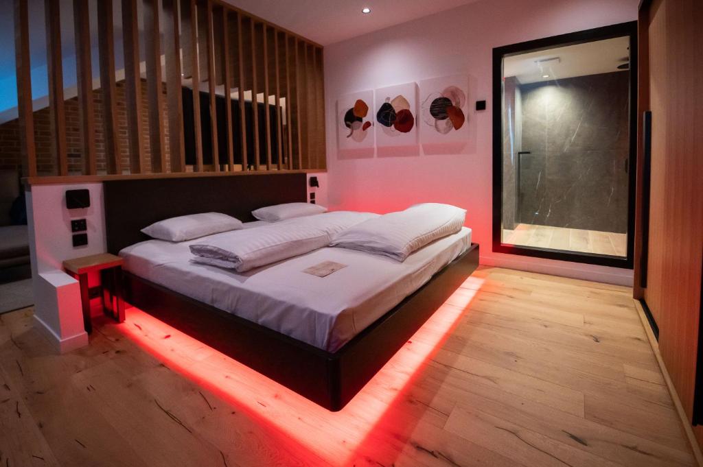 a bedroom with a bed with a red led lighting at Caro Hotel in Bucharest